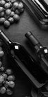 ein Tisch mit Flaschen Wein und Weintrauben