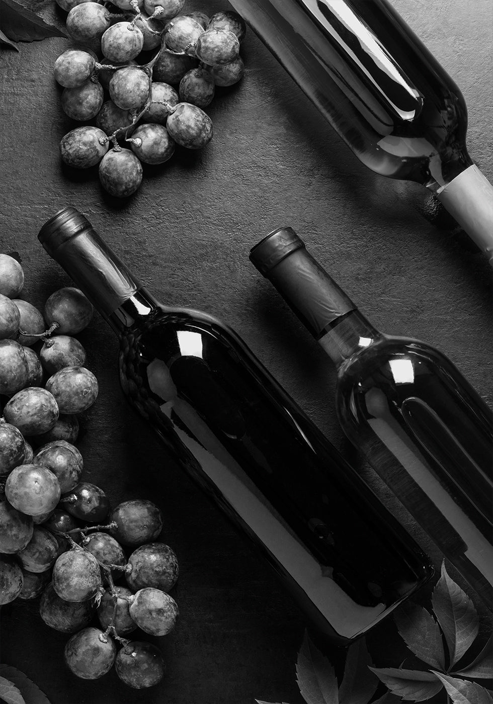 ein Tisch mit Flaschen Wein und Weintrauben