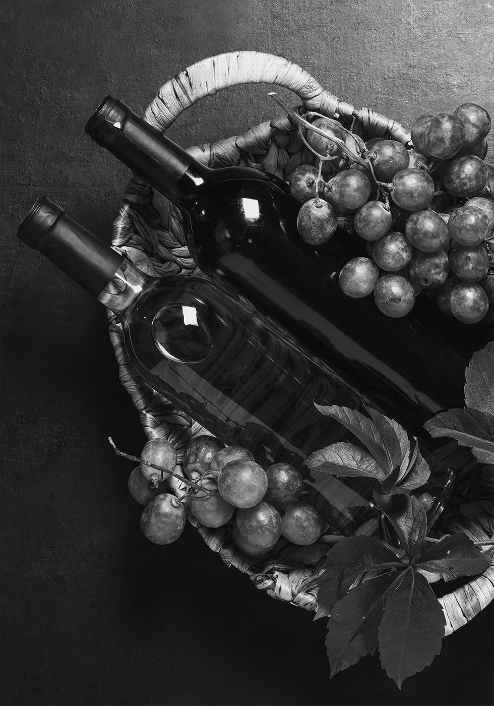 ein Korb voller Weintrauben und eine Flasche Wein