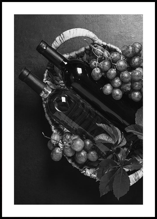 ein Schwarz-Weiß-Foto eines Korbes mit Weintrauben und einer Flasche Wein