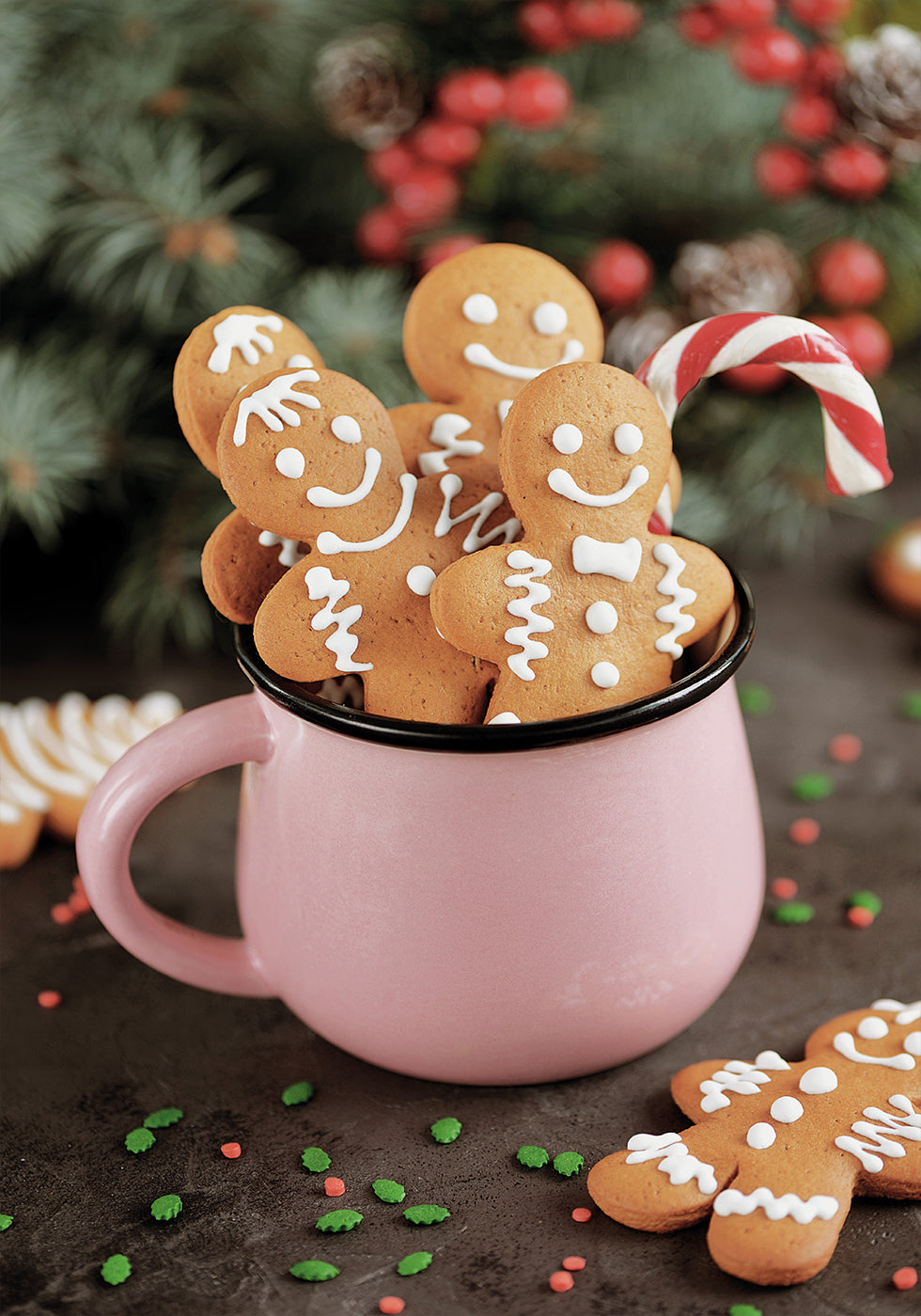 eine rosa Tasse voller Kekse und Zuckerstangen